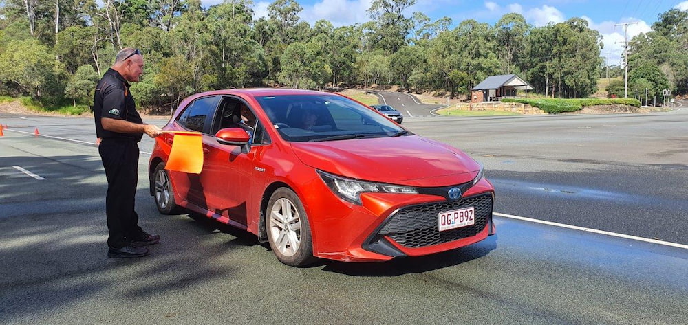 A red Toyota car on a checkpoint 